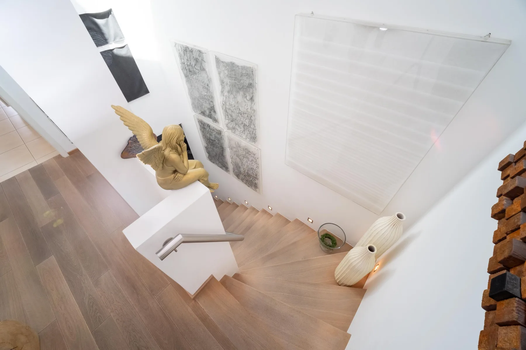 Offenes Treppenhaus mit Skulptur und Kunst an der Wand